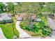 Aerial view of a home with a manicured lawn, mature trees, and a one-car garage at 3572 Pocahontas Dr, Largo, FL 33774