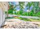 Back patio overlooking a yard surrounded by a white fence and lush trees at 3572 Pocahontas Dr, Largo, FL 33774