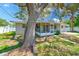Exterior of home features a screened-in lanai, a concrete patio, and green grass at 3572 Pocahontas Dr, Largo, FL 33774