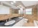 Well-lit bathroom featuring a double sink vanity with granite countertop, tile backsplash, toilet, and tub/shower at 3572 Pocahontas Dr, Largo, FL 33774