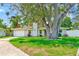 Charming home with a manicured lawn, mature trees, and attached one-car garage at 3572 Pocahontas Dr, Largo, FL 33774