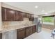 Well-equipped kitchen with granite countertops, stainless steel appliances, and dark wood cabinets at 3572 Pocahontas Dr, Largo, FL 33774