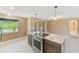 Modern kitchen island with stainless steel cooktop and dark wood cabinetry with backyard views at 3572 Pocahontas Dr, Largo, FL 33774