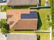 Aerial view of home with solar panels, roof, and surrounding landscaping at 4247 Balmoral Ct, Wesley Chapel, FL 33543
