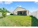 Large backyard with lush green grass, enclosed with a white fence at 4247 Balmoral Ct, Wesley Chapel, FL 33543