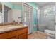 Bathroom showcasing a tiled shower with glass doors, granite countertops, and light teal colored walls at 4247 Balmoral Ct, Wesley Chapel, FL 33543