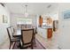 Bright dining room with a chandelier and a view into the kitchen featuring wooden cabinets at 4247 Balmoral Ct, Wesley Chapel, FL 33543