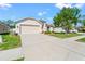 Lovely home featuring an attached garage, a well-manicured lawn, and sidewalk leading to the front door at 4247 Balmoral Ct, Wesley Chapel, FL 33543