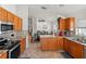 Well-lit kitchen with tile backsplash, wooden cabinets, granite countertops, and stainless steel appliances at 4247 Balmoral Ct, Wesley Chapel, FL 33543