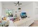Spacious living room featuring a vaulted ceiling, access to the lanai, and a large TV at 4247 Balmoral Ct, Wesley Chapel, FL 33543