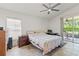Bright main bedroom featuring a ceiling fan, window blinds, and sliding glass doors to the lanai at 4247 Balmoral Ct, Wesley Chapel, FL 33543