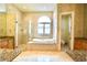 Bright bathroom showcasing a soaking tub, a glass shower, and dual vanities with granite counters at 441 Lucerne Ave, Tampa, FL 33606