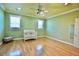 Light-filled bedroom showcasing hardwood floors, neutral walls, a white crib and two shuttered windows at 441 Lucerne Ave, Tampa, FL 33606