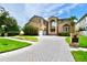 Stunning two-story brick home with an arched entry, a circular driveway, and lush landscaping at 441 Lucerne Ave, Tampa, FL 33606