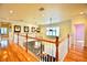 Upstairs hallway with hardwood floors and framed sports jerseys at 441 Lucerne Ave, Tampa, FL 33606