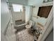 Bathroom in disrepair features tiled walls, a bathtub with shower curtain, and a toilet needing replacement at 5012 Osprey Ln, New Port Richey, FL 34652