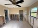 Bedroom with damaged walls features tiled flooring, ceiling fan, and a sliding door closet, ready for renovation at 5012 Osprey Ln, New Port Richey, FL 34652