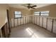 An empty bedroom with damage along the walls, awaiting renovation with abundant natural light and a ceiling fan at 5012 Osprey Ln, New Port Richey, FL 34652