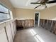 Bedroom showcasing damage along the walls needing renovation, light filled with tiled floor and ceiling fan at 5012 Osprey Ln, New Port Richey, FL 34652