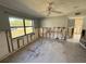 Bright living room featuring a ceiling fan, tiled flooring, and a large window with a backyard view at 5012 Osprey Ln, New Port Richey, FL 34652