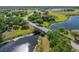 Scenic aerial view of a charming bridge crossing a tranquil body of water surrounded by lush greenery at 5214 Lake Venice Dr, Wimauma, FL 33598
