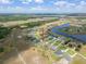 Aerial view of a community with a winding waterway and homes with private swimming pools and manicured lawns at 5214 Lake Venice Dr, Wimauma, FL 33598