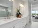 Bright bathroom featuring dual sink vanity with granite countertop and modern fixtures at 5214 Lake Venice Dr, Wimauma, FL 33598
