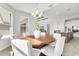 Elegant dining area with a round table, seating for six, and modern chandelier lighting at 5214 Lake Venice Dr, Wimauma, FL 33598