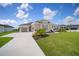 Beautiful single-story home featuring a three-car garage, well-manicured lawn and tasteful landscaping at 5214 Lake Venice Dr, Wimauma, FL 33598