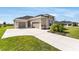 Attractive single-story home featuring a three-car garage and a well-manicured lawn at 5214 Lake Venice Dr, Wimauma, FL 33598
