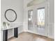 Inviting foyer featuring glass double doors, stylish decor, and wood-look flooring at 5214 Lake Venice Dr, Wimauma, FL 33598
