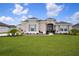 Inviting single-story home featuring a well-manicured lawn, mature trees, and tasteful landscaping at 5214 Lake Venice Dr, Wimauma, FL 33598