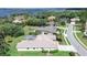 Overhead shot of house in a leafy neighborhood with a screened-in pool near a beautiful lake at 5460 Millbrook Way, Palm Harbor, FL 34685