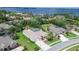 An aerial perspective of a home with a screened pool and lawn, in a lakeside community at 5460 Millbrook Way, Palm Harbor, FL 34685