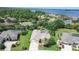 An elevated view of a home featuring a screened pool, landscaping, and access to a scenic lake at 5460 Millbrook Way, Palm Harbor, FL 34685