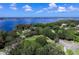 Stunning aerial view of a community's manicured lawns, lush trees, and scenic waterfront on a bright, sunny day at 5460 Millbrook Way, Palm Harbor, FL 34685