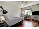 Cozy bedroom with hardwood floors, a ceiling fan, and a bright window with a workspace at 5460 Millbrook Way, Palm Harbor, FL 34685