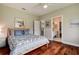Cozy bedroom with hardwood floors, a queen bed, and views of the en suite bathroom at 5460 Millbrook Way, Palm Harbor, FL 34685
