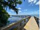 View of a community pier extending over tranquil waters under a bright blue sky at 5460 Millbrook Way, Palm Harbor, FL 34685