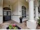Welcoming front entrance with a decorative door, arched window, and lush flowerpots at 5460 Millbrook Way, Palm Harbor, FL 34685