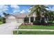 Charming single-story home with a well-manicured lawn, mature palm trees, and a three-car garage at 5460 Millbrook Way, Palm Harbor, FL 34685