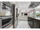 Contemporary kitchen featuring stainless steel appliances, sleek white cabinets and a dark wood island at 5460 Millbrook Way, Palm Harbor, FL 34685