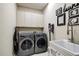 Well-equipped laundry room with modern washer, dryer, sink and storage cabinets at 5460 Millbrook Way, Palm Harbor, FL 34685