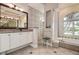Well-lit main bathroom featuring a soaking tub, walk-in shower, and granite countertop at 5460 Millbrook Way, Palm Harbor, FL 34685