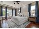 Bright main bedroom with a large bed, stylish rug, and views to the outdoor pool area at 5460 Millbrook Way, Palm Harbor, FL 34685