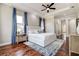 Spacious main bedroom featuring a king bed, elegant decor, and wood flooring at 5460 Millbrook Way, Palm Harbor, FL 34685