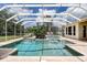 Enclosed pool with brick surround, lounge chair, and outdoor seating in the beautiful backyard at 5460 Millbrook Way, Palm Harbor, FL 34685