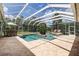 Inviting in-ground pool in a screened enclosure, complete with seating areas and lush landscaping at 5460 Millbrook Way, Palm Harbor, FL 34685