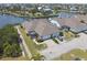 Aerial view of the home showcasing the two-car garage, screened-in lanai, and lush landscaping bordering a canal at 5702 Tides Pl, Apollo Beach, FL 33572