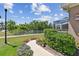 Well-maintained yard with manicured bushes, colorful flowers, and a view of the screened-in lanai at 5702 Tides Pl, Apollo Beach, FL 33572